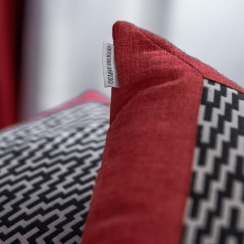 cuscini con rivestimento personalizzato con motivi geometrici bianco e nero e bordato di rosso